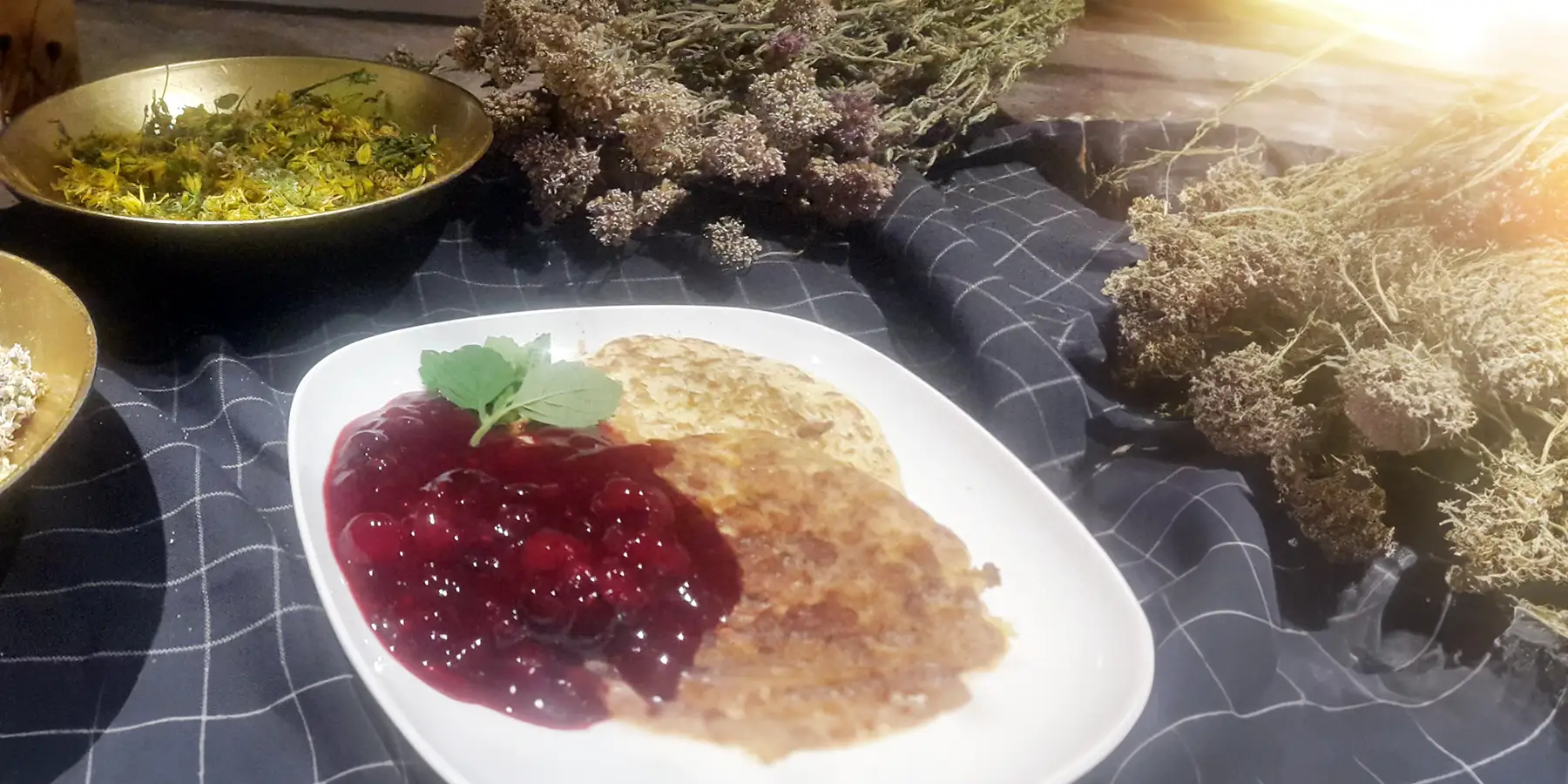 Ein Teller mit einer Portion Rote Grütze & Hirsefladen.
